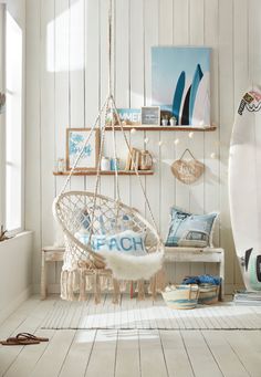 a living room with a surfboard on the wall and a hammock chair