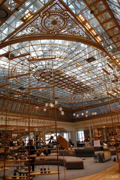 the inside of a large building with lots of glass and metal structures hanging from it's ceiling