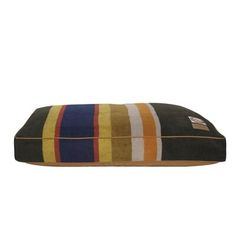 a dog bed with multicolored stripes on it