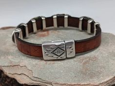 The Southwest Sunburst bracelet has 4 Southwest sliders that are on embossed leather with a Southwestern pattern. Magnetic clasp with an easy open thumbnail slot that stays put. The components are zinc plated with 99.9% sterling silver. Free of nickel, lead, cadmium. Hypoallergenic. The leather is 10mm in width. One size fits most. 8" Talc Powder, Hooked Pillow, Hat Holder, Southwestern Patterns, Laura Ingalls, Rustic Brown, Magnetic Clasp, Leather Band, Embossed Leather