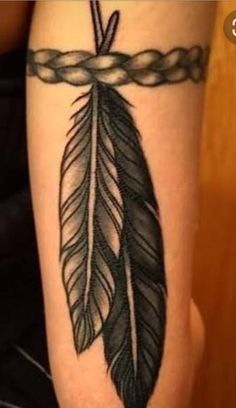 a black and white tattoo with a feather on it