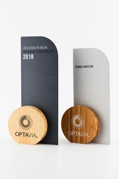 the award is presented in front of two wooden plaques, one with an optava logo on it