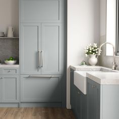 a kitchen with blue cabinets and white counter tops, wood floors and wooden flooring