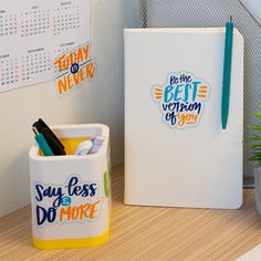 two office supplies are sitting on a desk next to a calendar, pen and pencil holder