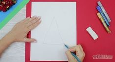 someone is drawing a triangle on paper with crayons and pencils next to it