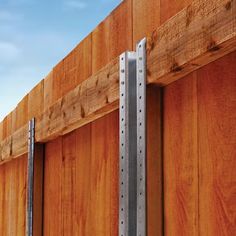 a wooden fence with two metal brackets attached to it