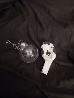 an ornament and paper on a black cloth next to a glass ornament