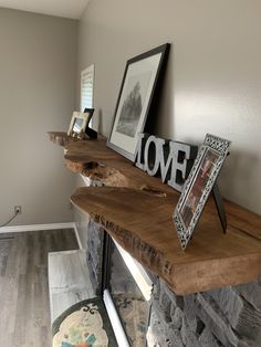 there is a wooden shelf on top of the fireplace mantel with pictures and frames