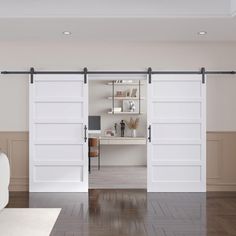 a living room with white furniture and sliding doors