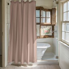 a bathroom with a tub, shower curtain and window in it's center area