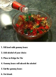 a glass bowl filled with gummy bears next to a bottle