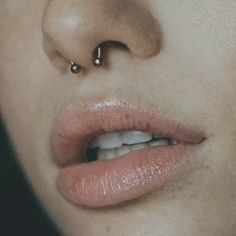 a woman's nose with two piercings on it