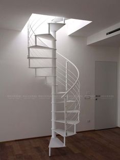 a white spiral staircase in an empty room