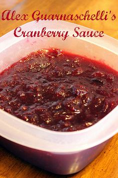 a container filled with cranberry sauce sitting on top of a wooden table