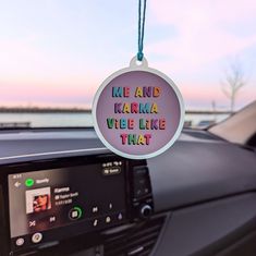 a car dashboard with a sign that says me and karma vibe like that hanging from the dash board