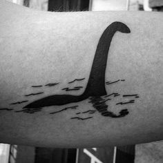 a person with a tattoo on their arm that has an image of a bird swimming in the water