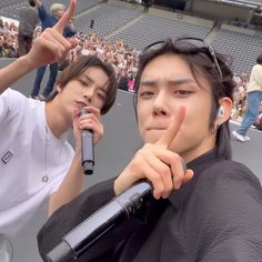 two young men standing next to each other with microphones in front of their faces