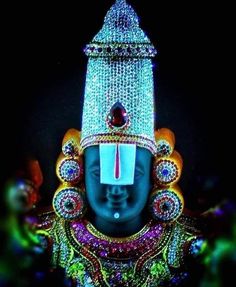 the head of a statue with jewels on it's forehead and eyes are lit up