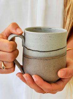 a woman holding a cup in her hands