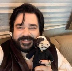 a man with a beard holding a stuffed monkey