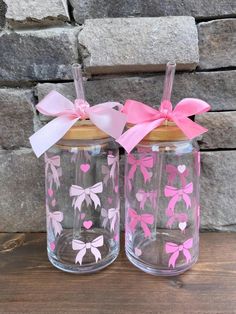 two glass jars with pink bows and hearts on them