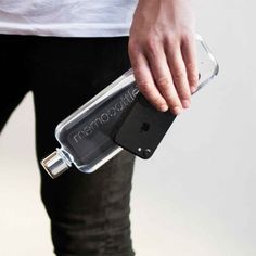 a person is holding an ipod in a water bottle