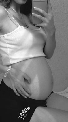 a pregnant woman taking a selfie with her cell phone