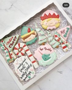 a box filled with decorated cookies on top of a table