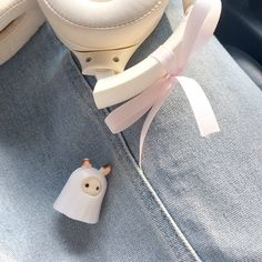 a small white object sitting on top of a blue chair next to a stuffed animal