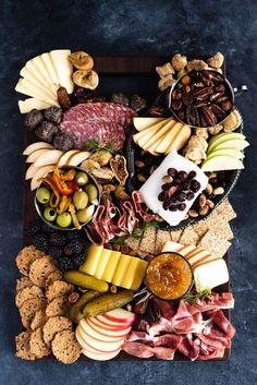 an assortment of cheeses, crackers, and meats on a platter