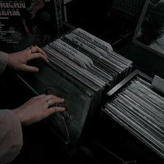 a person holding a record player in front of a bunch of records on a table