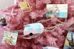 pink christmas tree decorated with pictures and magnets, including an old camper ornament