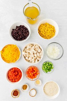 bowls filled with different types of food on top of a white counter next to a measuring cup