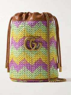 Gucci's bucket bag is patterned with chevron stripes in vibrant, summer-inspired tones. Made from straw, it's reinforced with leather trims and topped with the house's iconic 'GG' emblem. It's perfectly sized to fit your phone, keys and sunglasses and has internal slots for your most-used cards. Gucci Luxury Bucket Bag With Leather Handles, Gucci Multicolor Tote Bag, Designer Straw Bucket Bag With Braided Handles, Designer Woven Leather Straw Bucket Bag, Designer Woven Leather Bucket Straw Bag, Gucci Bucket Bag With Leather Handles, Designer Woven Bucket Bag, Designer Woven Bucket Shoulder Bag, Designer Bucket Straw Bag For Vacation