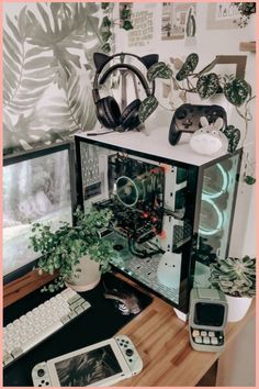 there is a computer on the desk with plants and other things in front of it