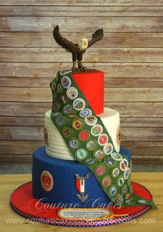 a multi - tiered cake with an eagle on top and ribbons around the edges