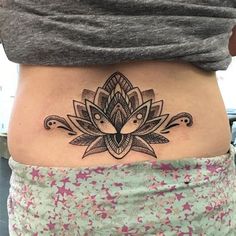 a woman's stomach with a tattoo design on the side of her belly,