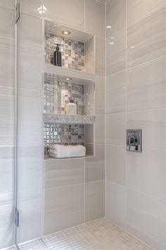 a walk in shower sitting next to a white tiled wall