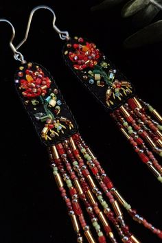 the earrings are decorated with red beads and gold trimmings, along with other beaded items