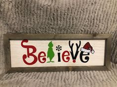 a wooden sign with the words believe in red, green and black letters on it