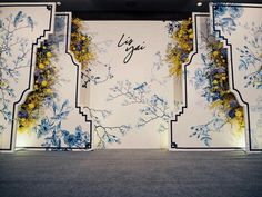 an artistic display with blue and yellow flowers on the wall, in front of a white background