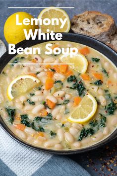 lemony white bean soup with spinach and carrots in a black bowl next to bread