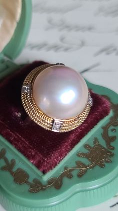 Gorgeous mid century Mabe Pearl and Diamond cocktail style ring crafted in 14k yellow gold. The natural Mabe Pearl displays an array of soft pastel colors. The luster and sheen are spectacular. Accenting the Mabe Pearl are four diamonds, each individually set in 14K white gold. They are placed along the yellow gold rope design rim.  Ring Measures 23mm in diameter  Mabe Pearl measures approximately 17mm Size 8 Hallmarks 14K 585 8.9 gms ttw Three Diamond Ring, Champagne Diamond Rings, Soft Pastel Colors, Diamond Cocktail Ring, Mabe Pearl, Diamond Cocktail Rings, Ring Crafts, Rope Design, Champagne Diamond