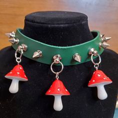 a black mannequin with two red and white mushrooms on it's collar