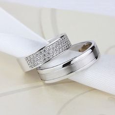 two white gold wedding bands with pave set diamonds on each one and the other side