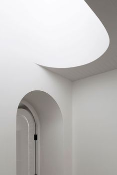 an empty room with white walls and arches