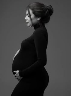 a pregnant woman poses for a black and white photo