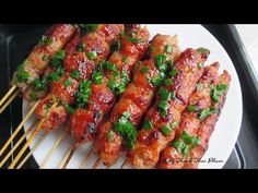 several skewers of meat covered in sauce and garnished with green onions