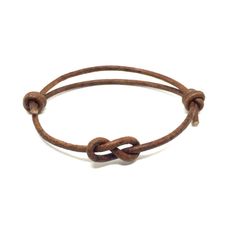 a brown leather bracelet with an oval knot on it