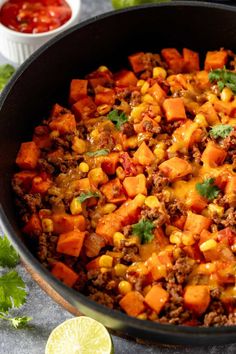 a skillet filled with taco meat, corn and cilantro on top of a table